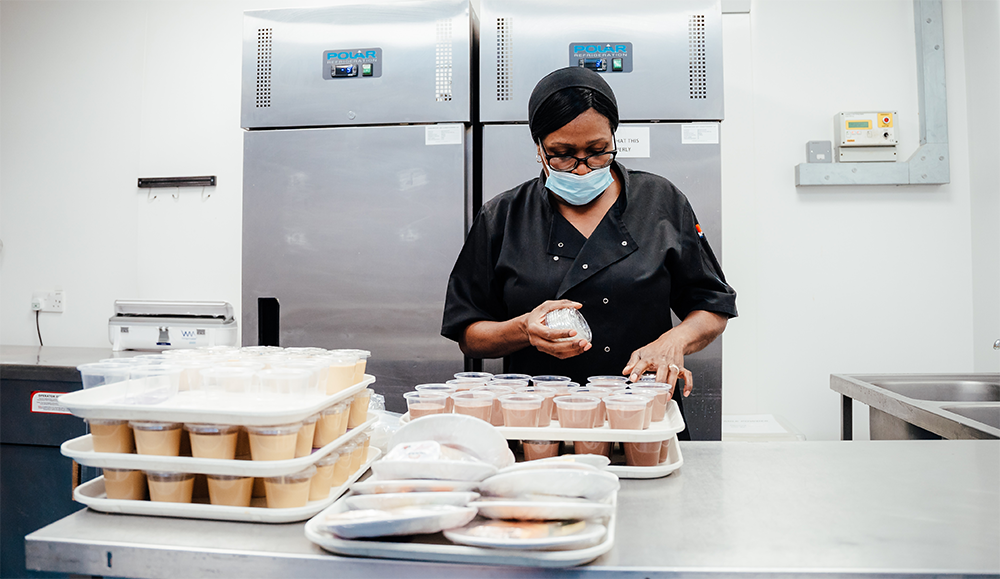 A member of the catering team prepares food in the kitchen